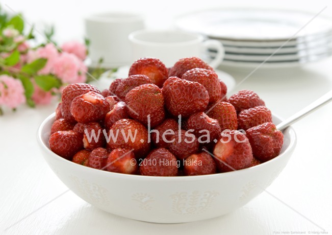 Plansch på nyplockade jordgubbar i vit skål. I bakgrunder syns koppar, assietter och rosor. Planschens storlek är A3, bilden är tryckt på glossy 200g papper vilket ger en stabil plansch med vackra färger. En 5 mm vit kant finns runt bilden 