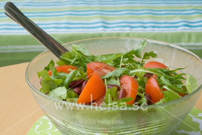 En grönsallad med tomat. Salladen innehåller även kidneybönor vilket gör salladen matigare och mer fiberrik.
