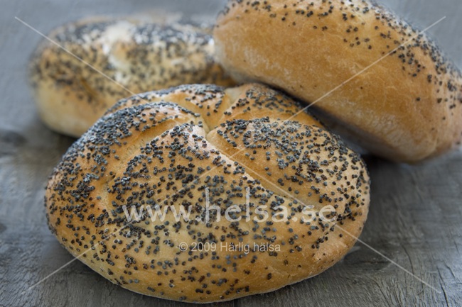 Tre bröd, med sesamfrön på ovansidan, ligger i en hög. Bröden är bakade på ljustmjöl och en del frön. 